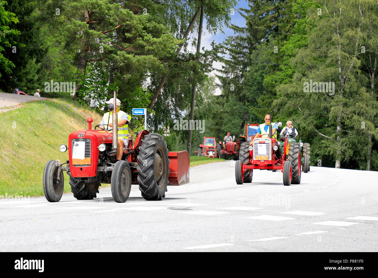 Vintage tractors drive in procession through Kimito community on Kimito Tractorkavalkad, Tractor Cavalcade. Kimito, Finland - July 7, 2018. Stock Photo