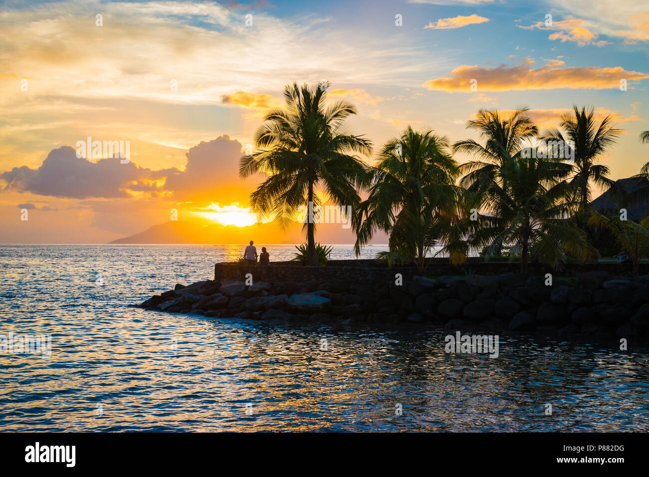 Silhouette of palm trees and sunset in Tahiti. Stock Photo