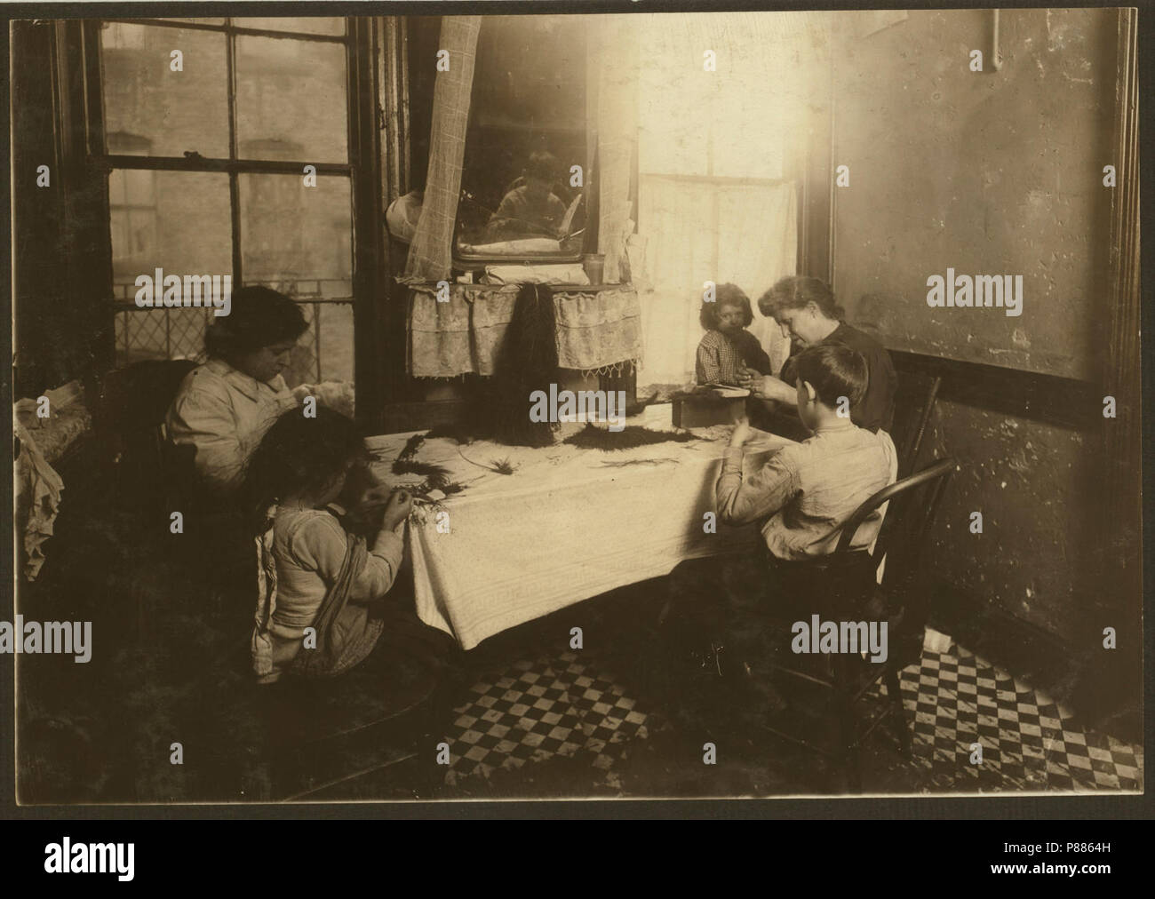 5 P.M. Mrs. Mary Molinari and family, 304 E. 107th St. 'We made feathers some, but not much.' Six-year-old Antoinette ties like an old hand. Dominick, 9 years old, works some. Annie 9, the Stock Photo