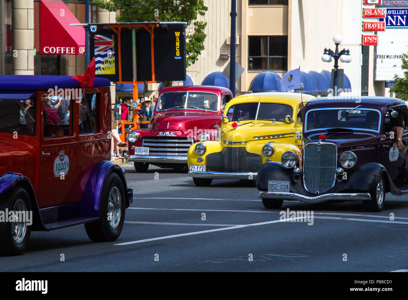 Classic cars from different eras in automobile history drive in parade