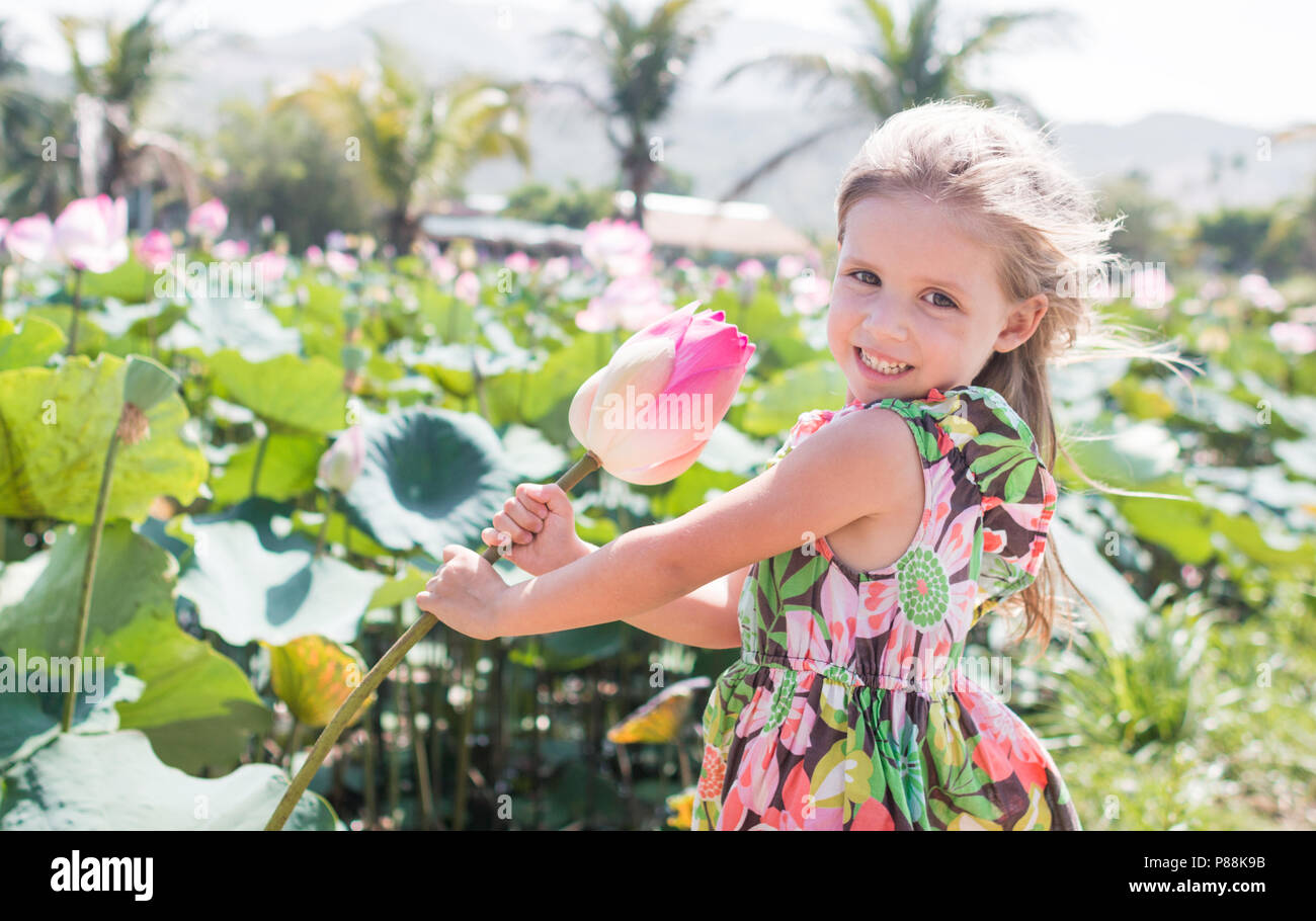 This beautiful waterlily or lotus flower. The girl hold in her hands a flower and smile Stock Photo