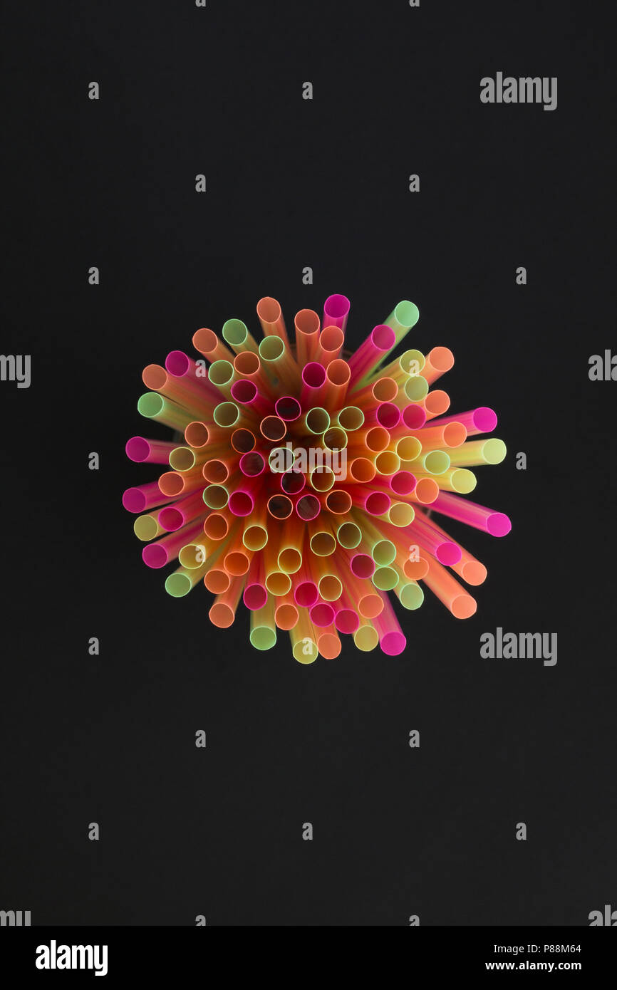 Creative view of drinking straws for party on black background in neon colors. Top view. Stock Photo