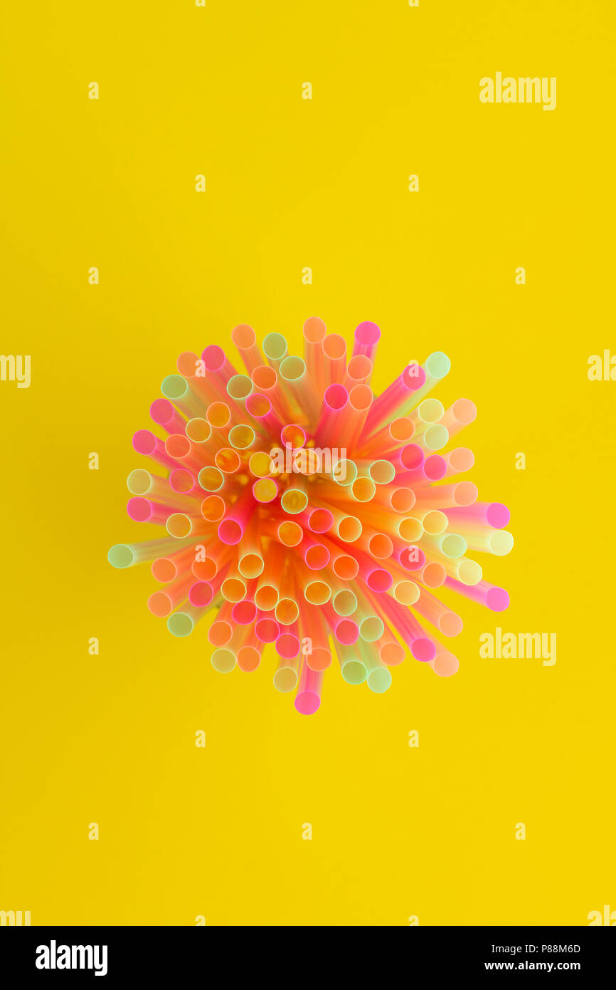 Creative view of drinking straws(neon colors) party on yellow background. Top view. Stock Photo