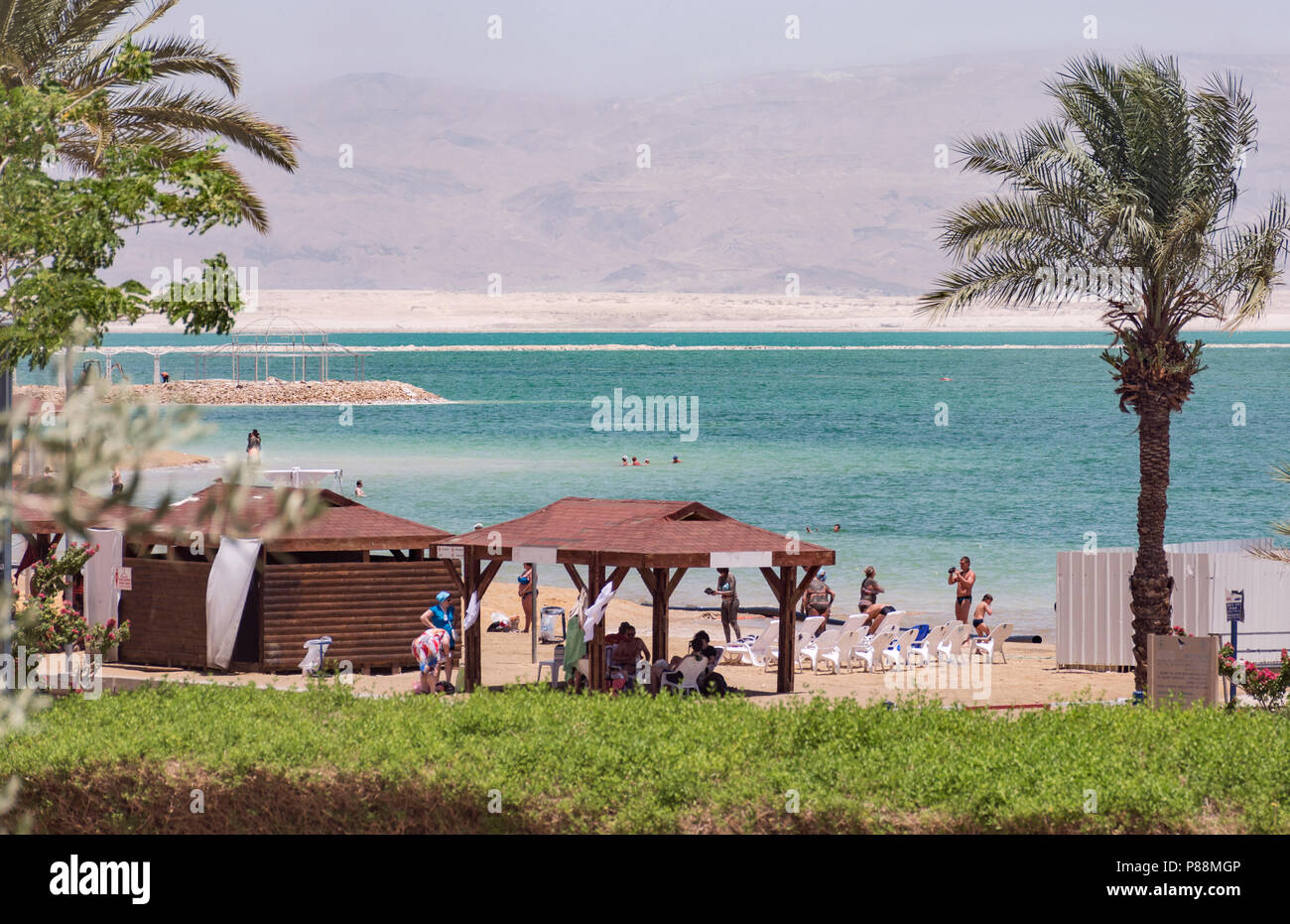 bathers and tourists enjoying a beach at Ein Bokek on the Dead Sea in Israel with Jordanian mountains in the background Stock Photo