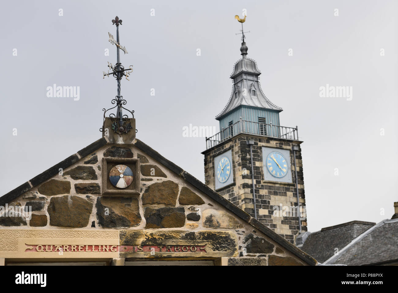 Quarrelling is Taboo on the Stirling Boys Club building with The Tolbooth clock tower Stirling Scotland UK Stock Photo