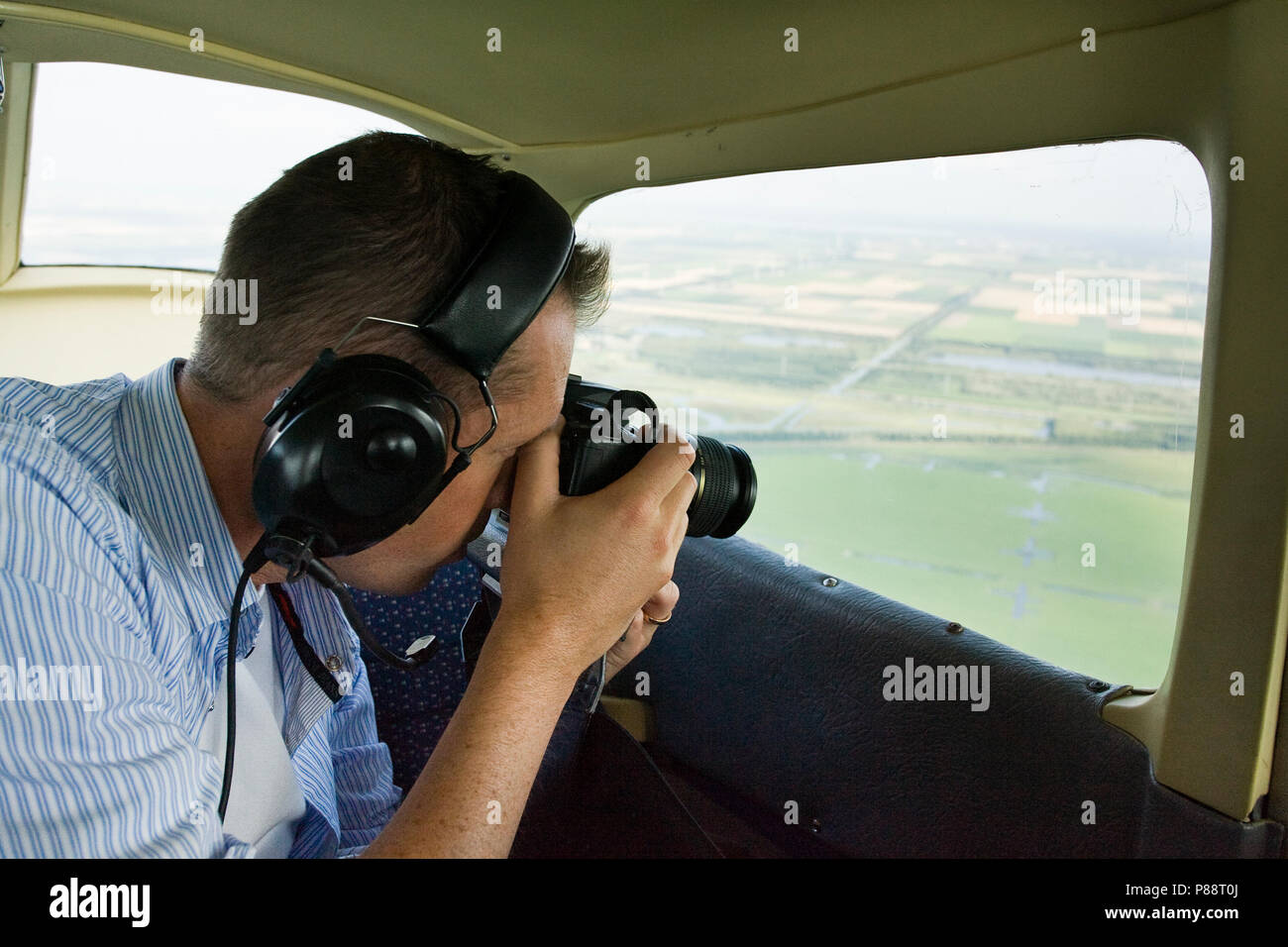 Fotograaf in vliegtuig; Photographer in airplane Stock Photo