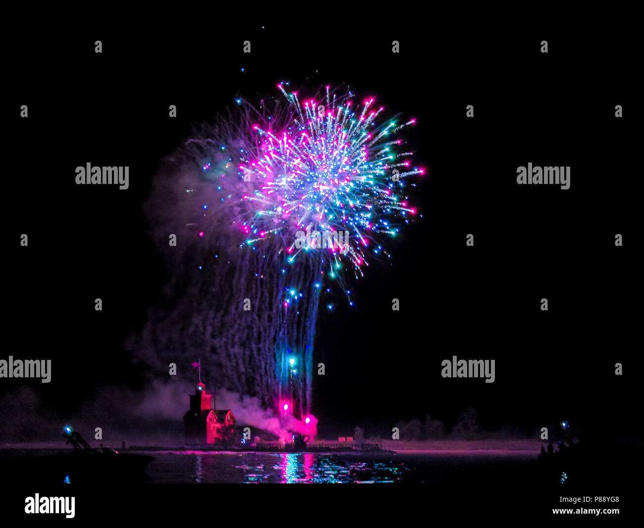 red lighthouse in Holland Michigan harbor with 4th of July fireworks