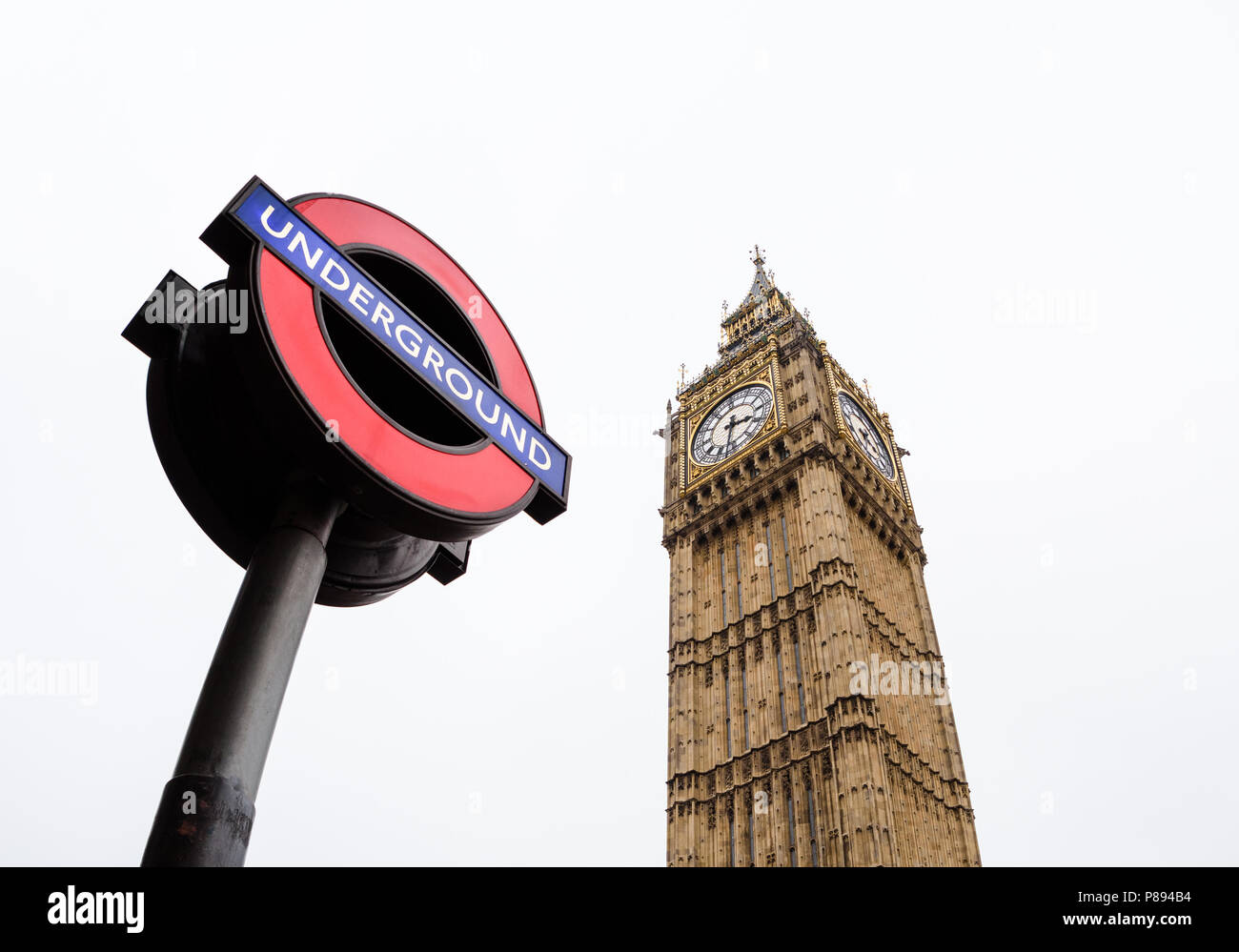 Looking up at Westminster station and underground sign and Big Ben in London against a clear sky taken with a wide angle lens Stock Photo