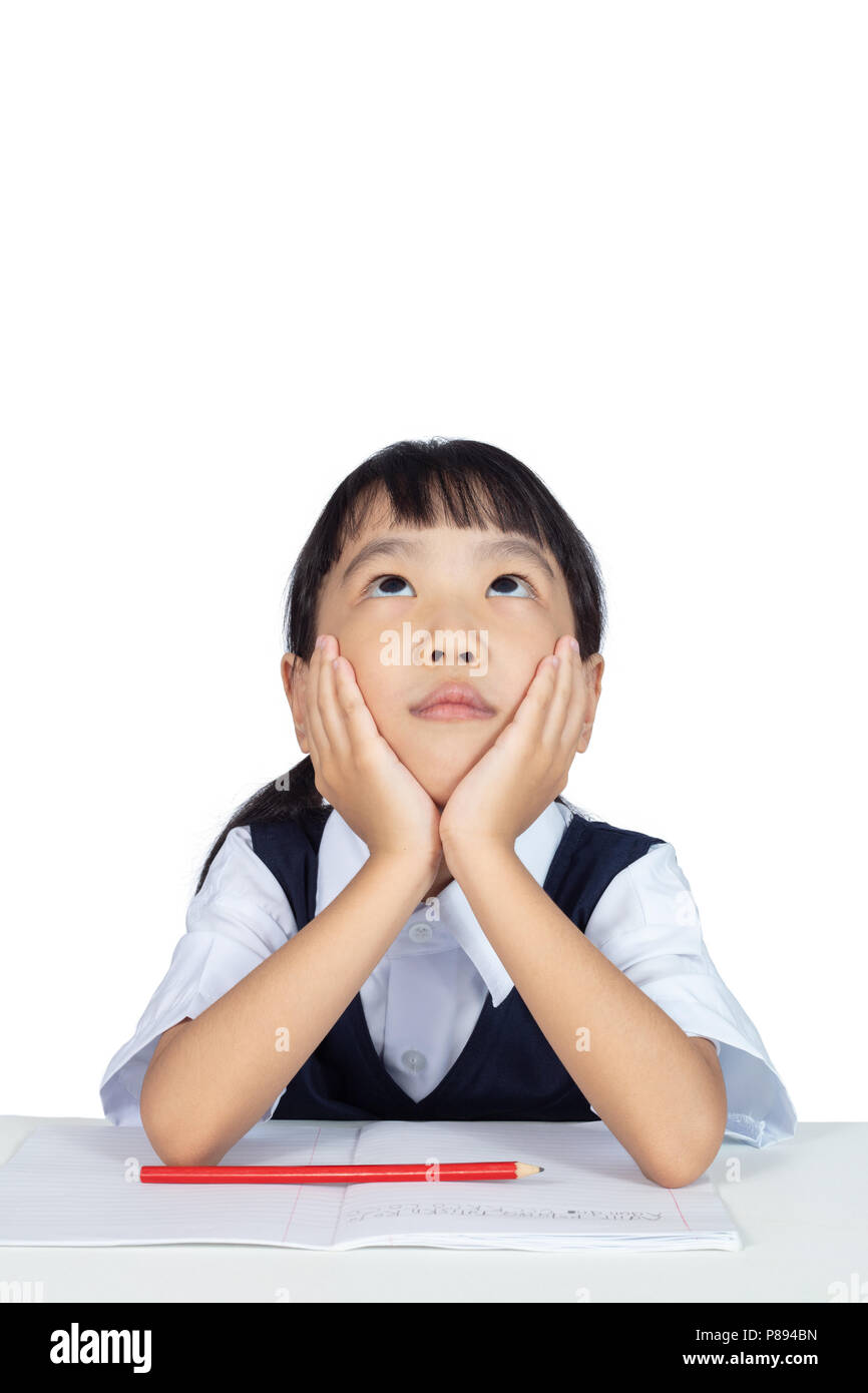 Asian Chinese little girl wearing school uniform studying in isolated white background Stock Photo