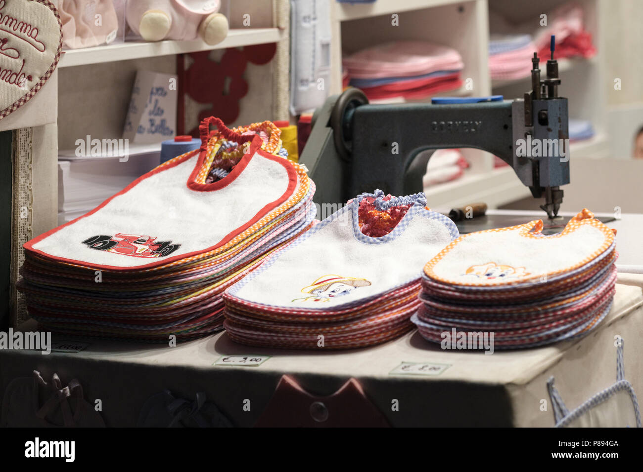 Babies bibs personally inscribed while you wait, old city shop in Lucca; Tuscany; Italy; Europe Stock Photo
