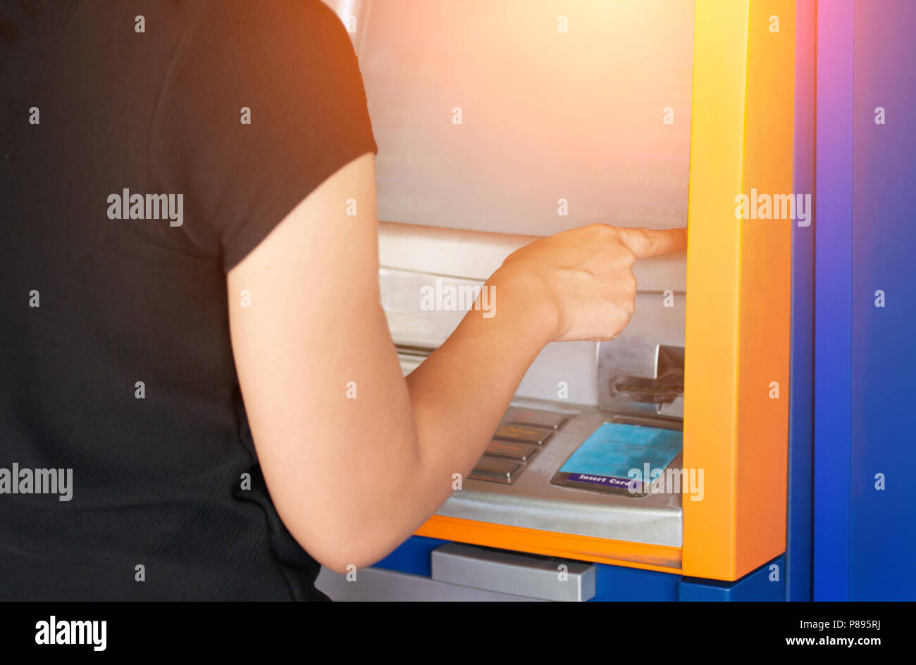 Woman pressing password number on blue ATM machine - Online banking ...