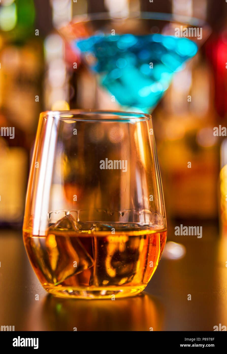 Scottish whisky in a glass with ice cubes, golden color whiskey