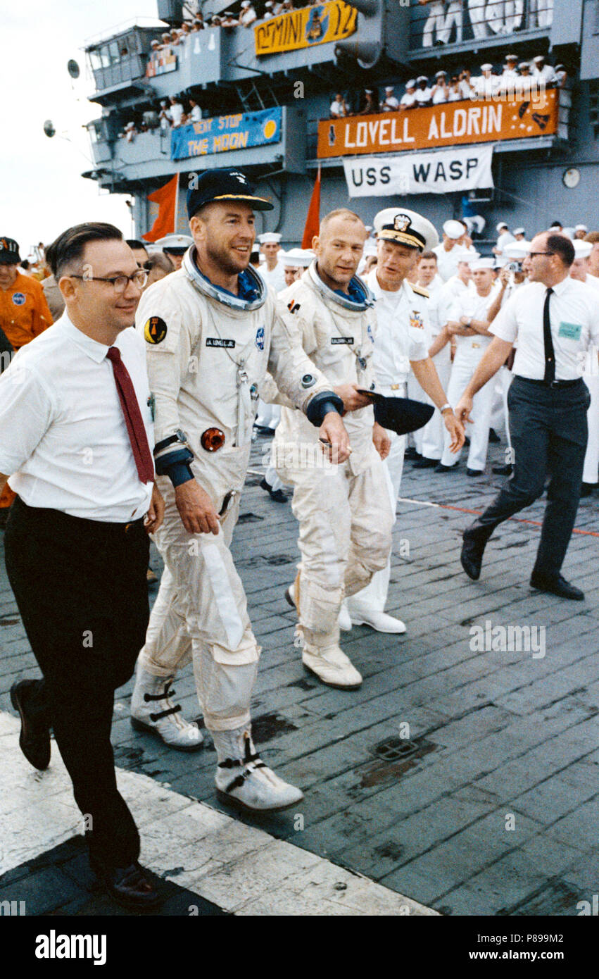 A happy Gemini-12 prime crew arrives aboard the aircraft carrier, USS Wasp. Astronauts James A. Lovell Jr. (L), and Edwin E. Aldrin Jr. had just been picked up from the splashdown area. Stock Photo