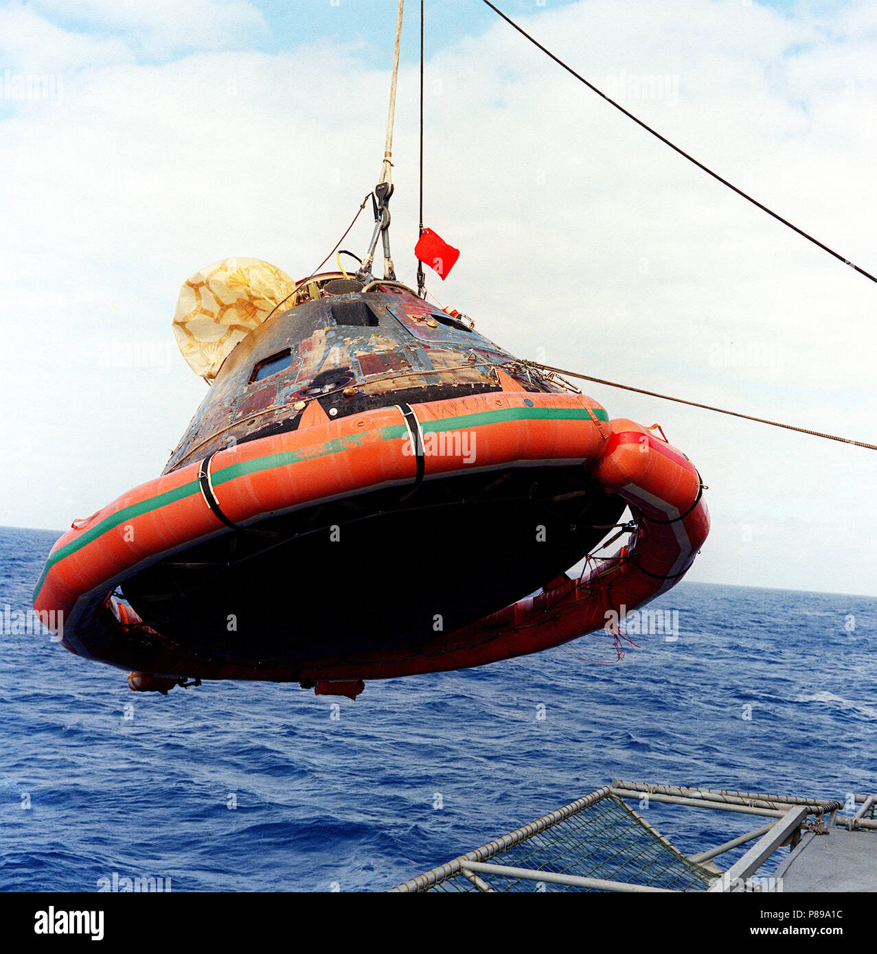 The Apollo 11 Command Module (CM) is photographed as it is hoisted aboard the USS Hornet, prime recovery vessel for the historic Apollo 11 lunar landing mission. Stock Photo