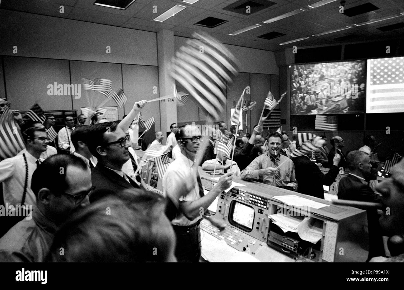 View of Mission Operations Control Room in the Mission Control Center (MCC), Manned Spacecraft Center (MSC), showing flight controllers celebrating successful conclusion of Apollo 11 mission. Stock Photo