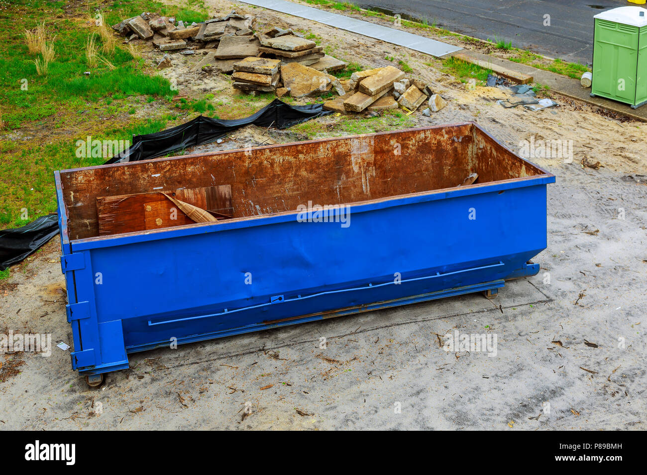 Industrial garbage bin blue construction debris container filled with