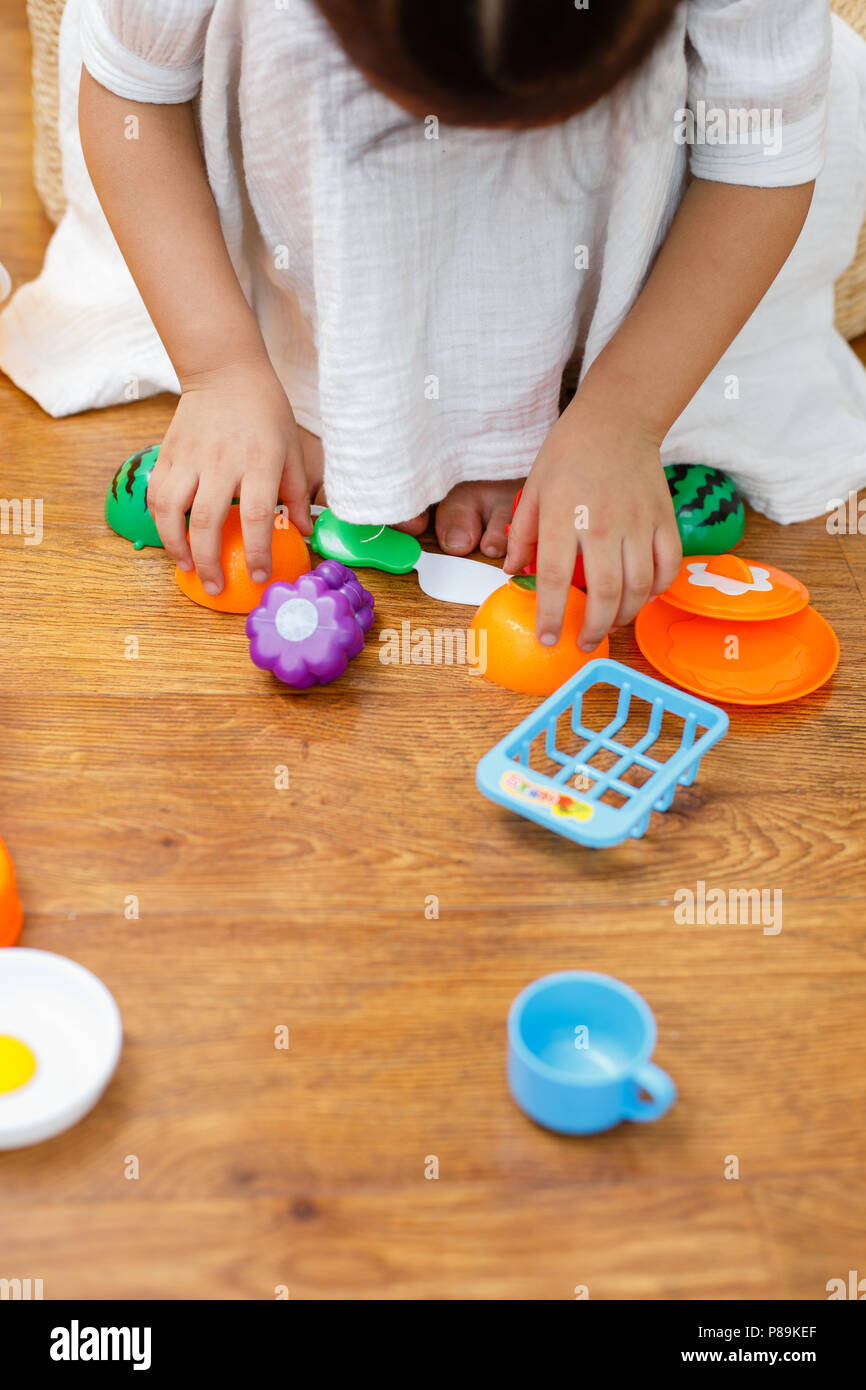 The Little Girl In White Is Playing Kitchen Games With Various