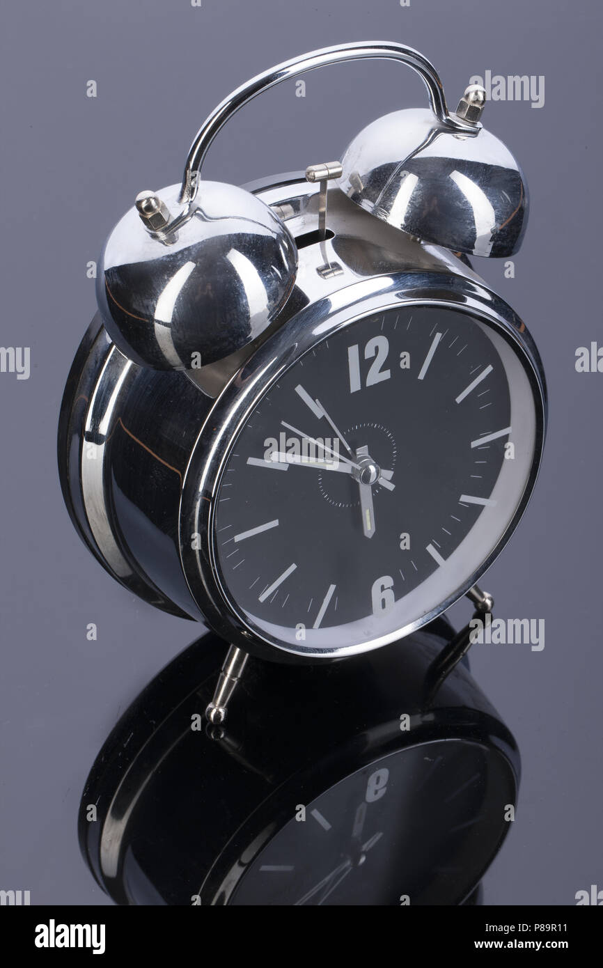 Alarm clock on a glass studio background Stock Photo