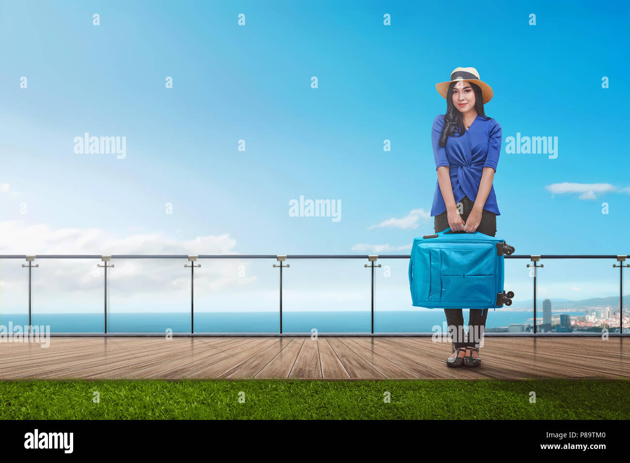 Pretty asian tourist woman with suitcase standing on balcony Stock Photo