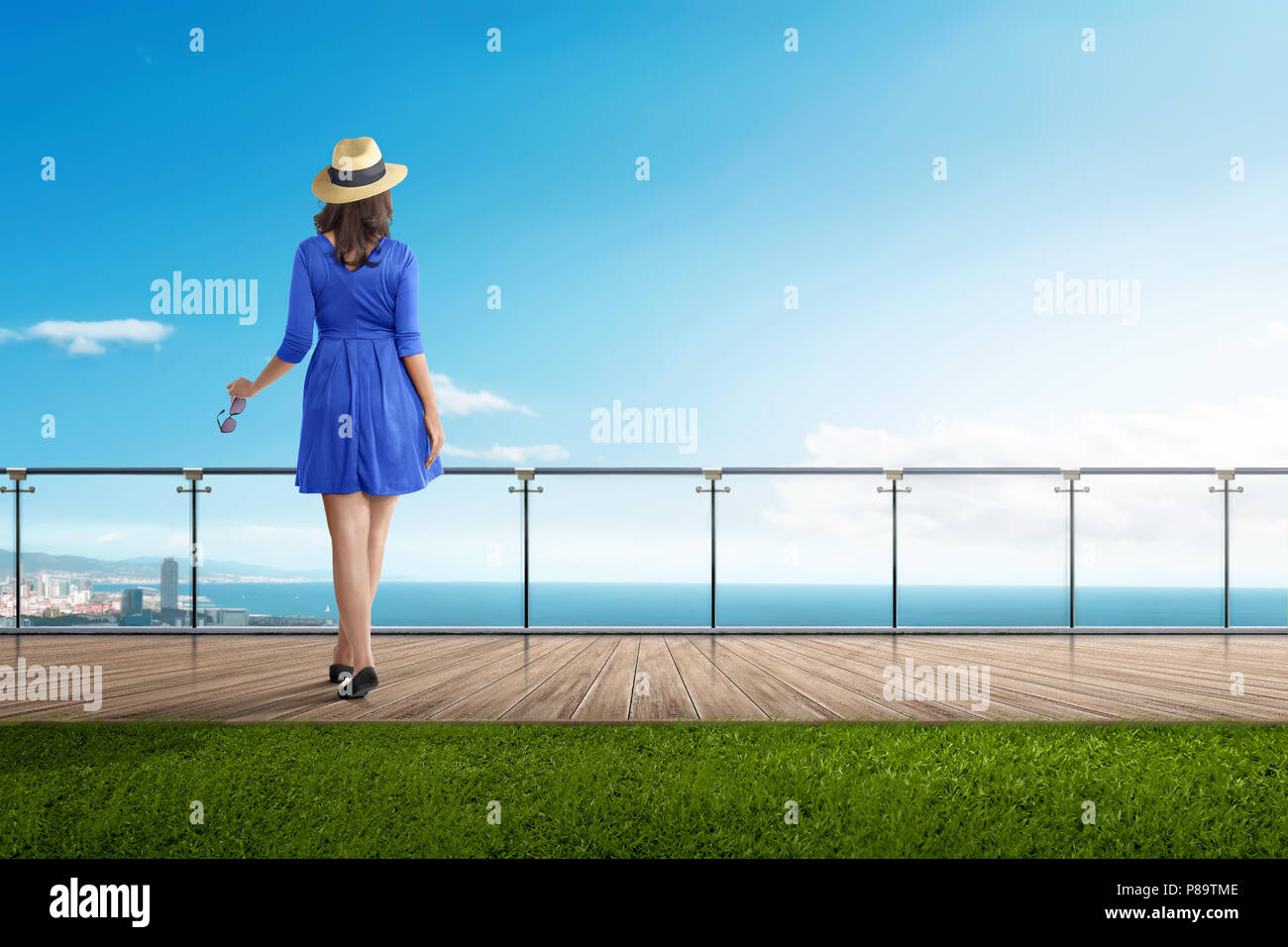 Rear view asian traveler woman standing on balcony with blue sky background Stock Photo