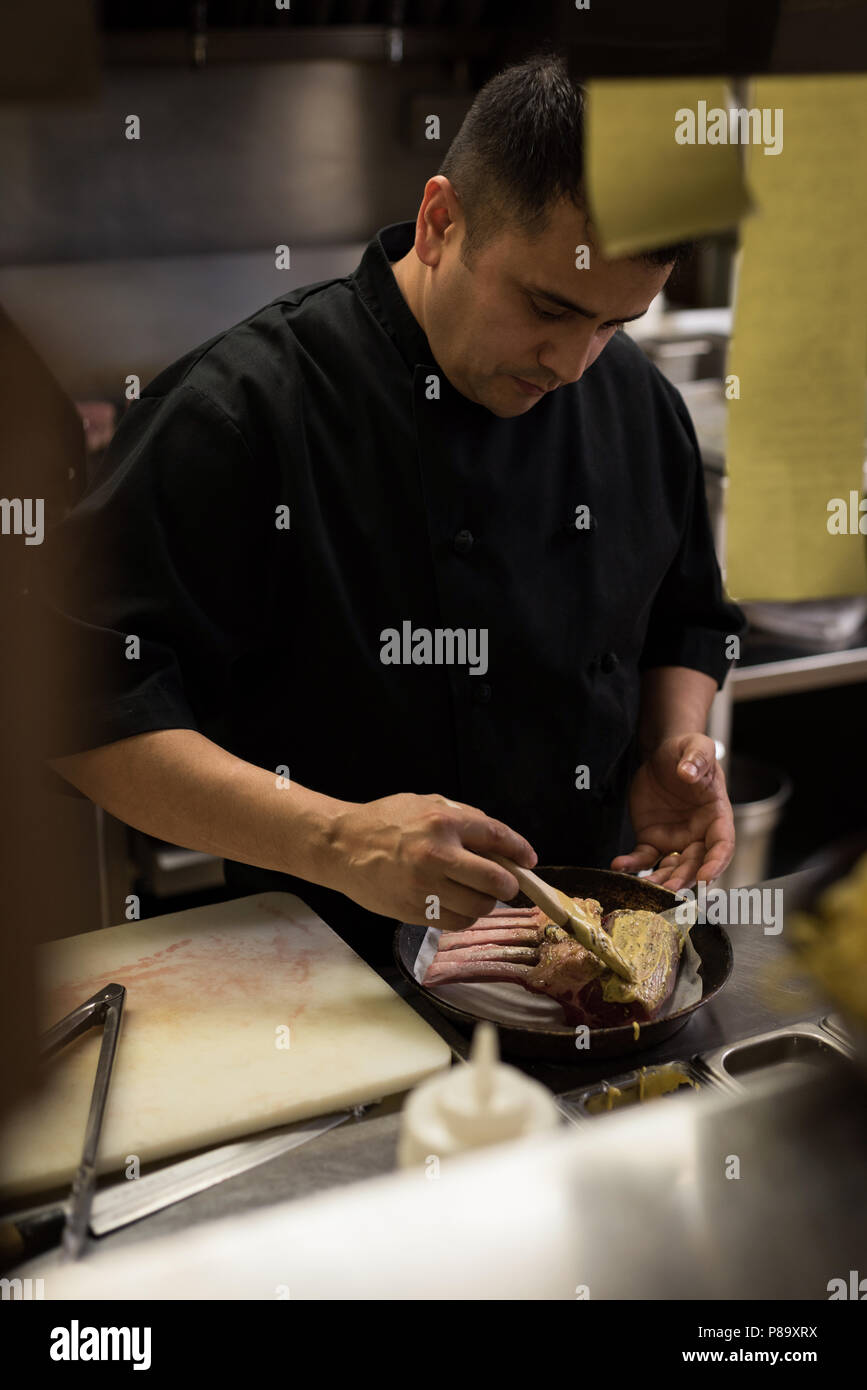 Male chef preparing meat in kitchen Stock Photo