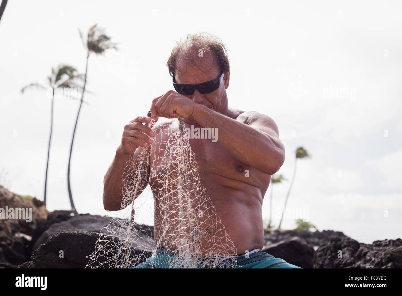 Fisherman holding fishing net Stock Photo