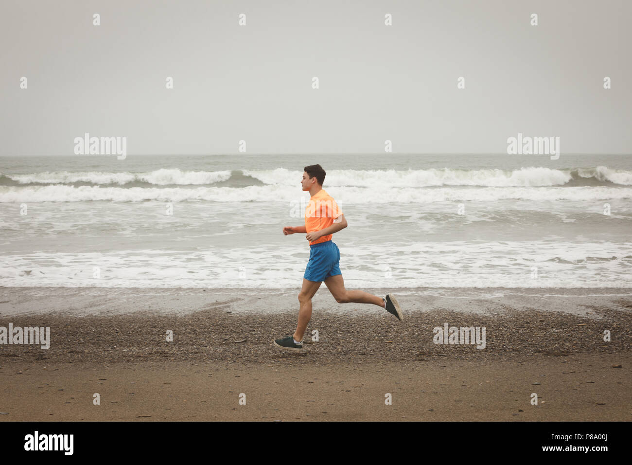 Man jogging on shore at beach Stock Photo