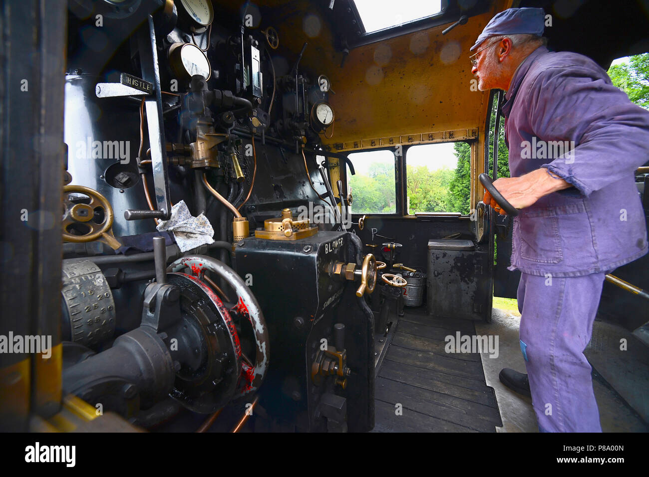 Transport, Rail, Steam Train, Watercress Line engine fireman loading the boiler with coal. Stock Photo