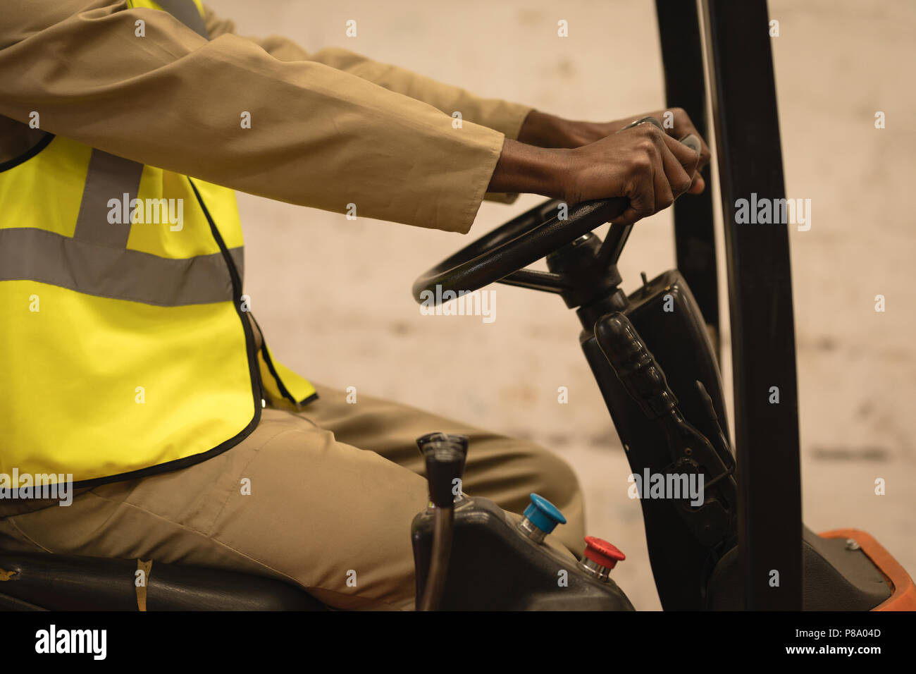 Male worker driving forklift in warehouse Stock Photo