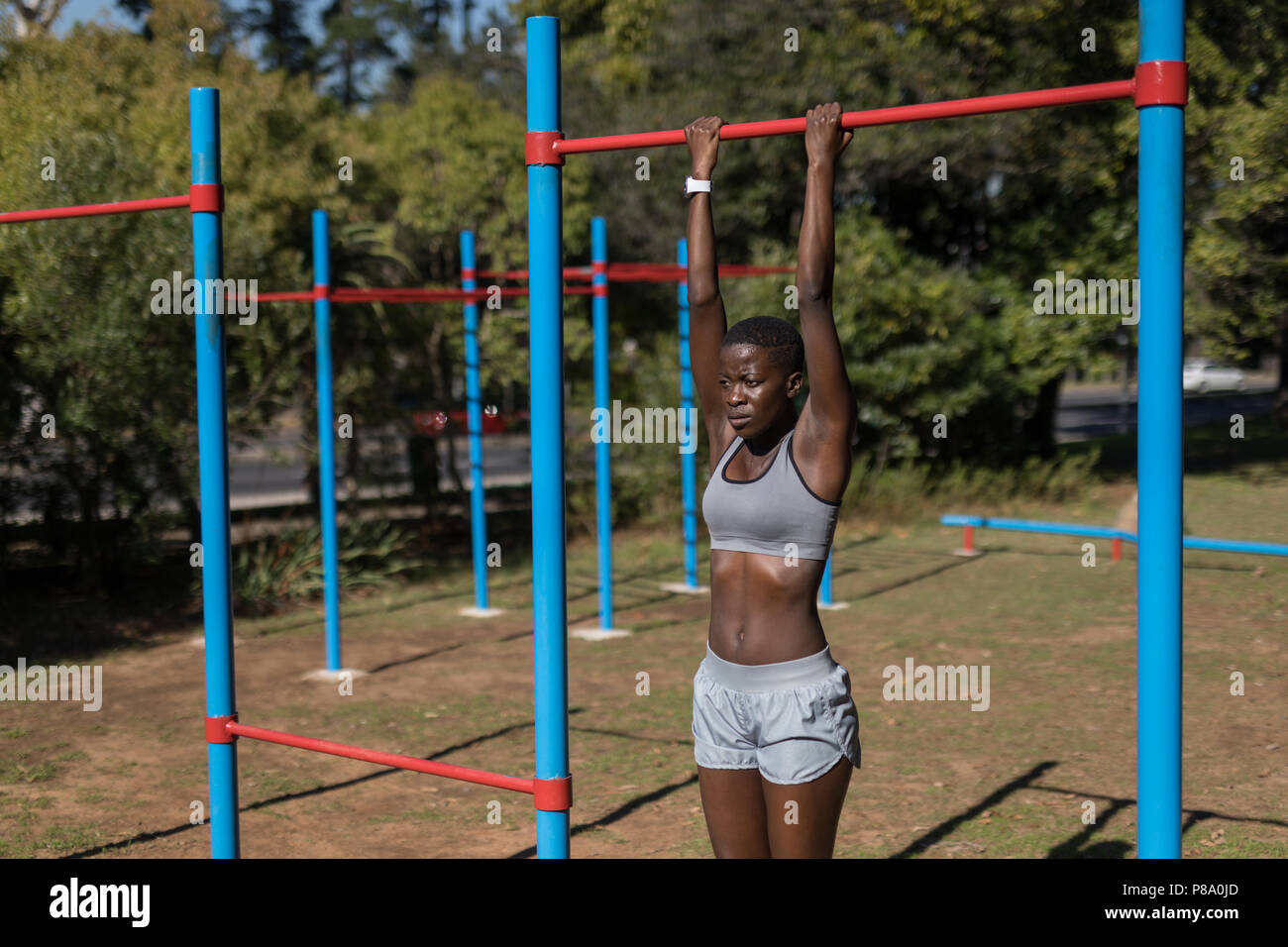 Female athlete doing pull ups on the bars Stock Photo