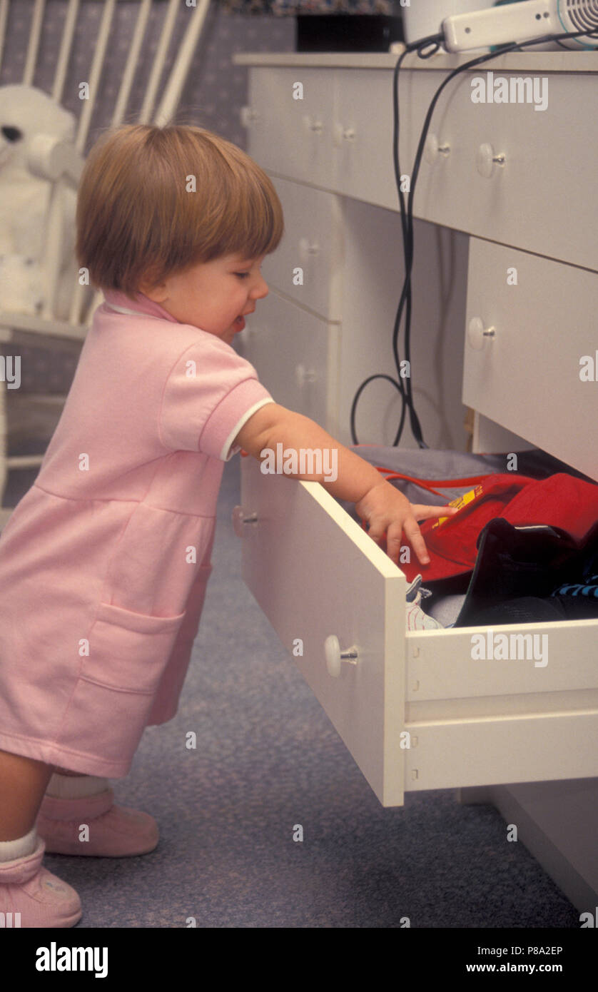 toddler pulling things out of drawer in danger of accident with hair