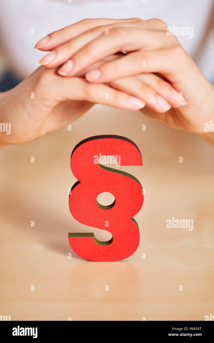 Justice concept with hands over a red paragraph sign Stock Photo
