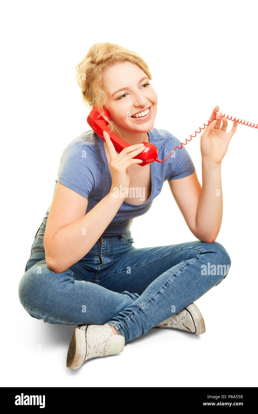 Young woman phoning with an analog phone cross-legged Stock Photo