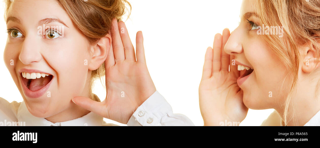 Two young women talk and listen with hand to mouth and ear Stock Photo
