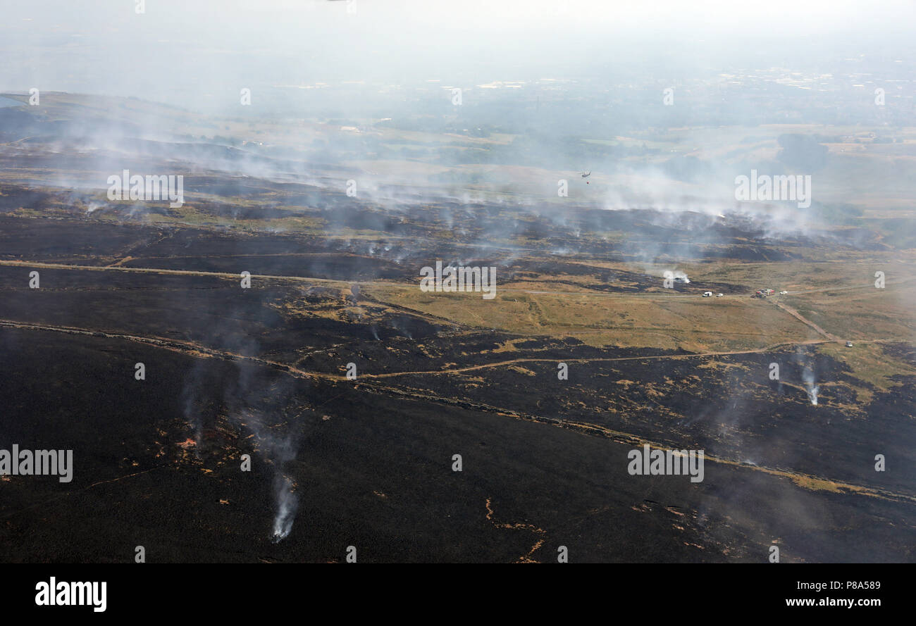aerial view of a helicopter dropping water on moorland fires on Winter Hill near Manchester Stock Photo