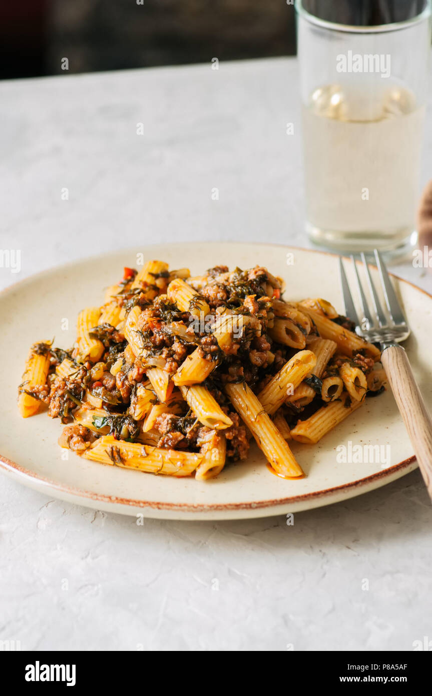 Tomato sauce ground beef pasta on a white stone background. Toned Stock