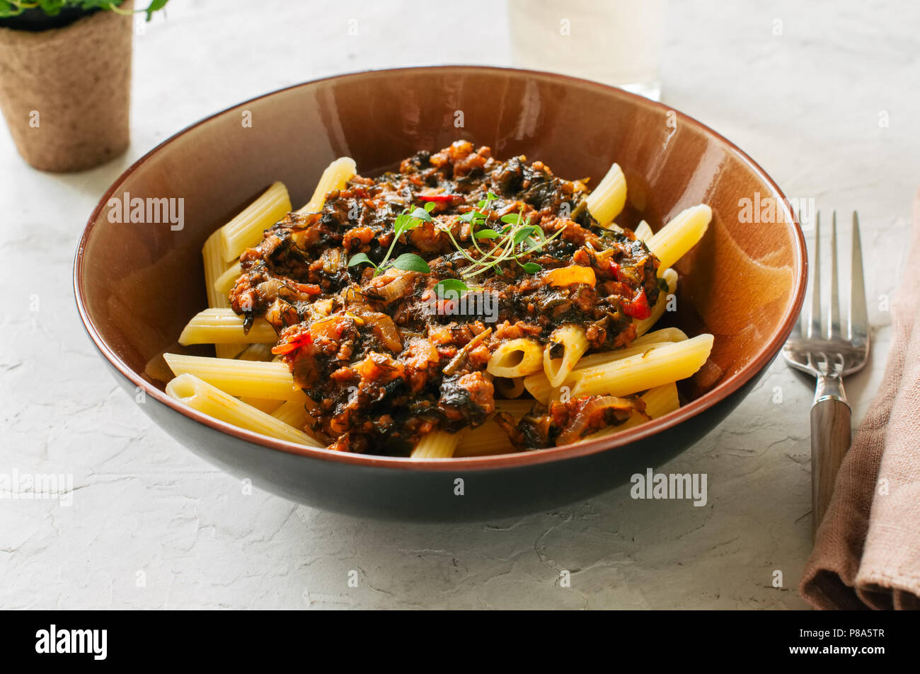 Tomato sauce ground beef pasta on a white stone background. Toned Stock