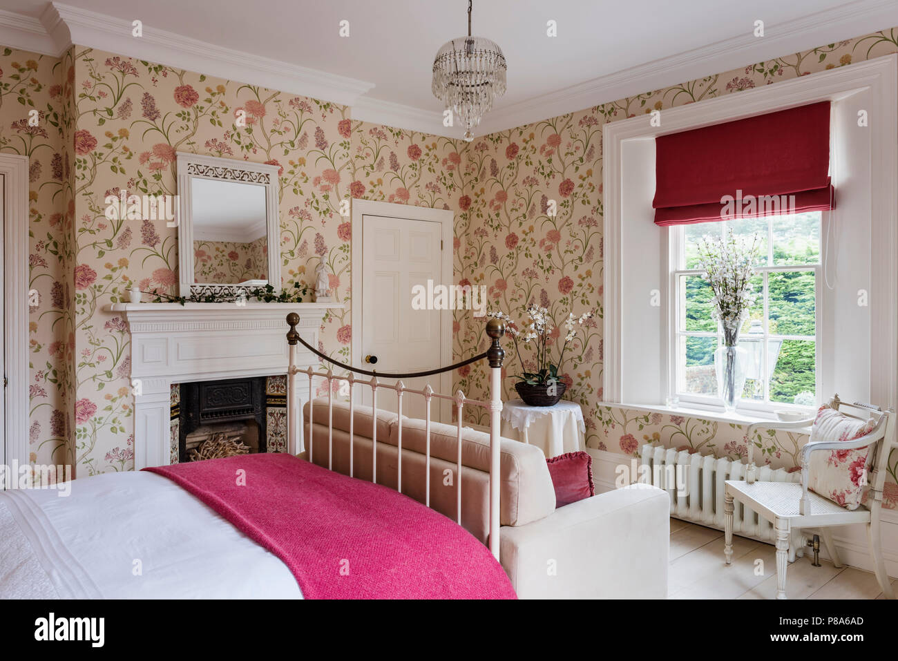 Bright pink blanket on metal framed bed in Regency home with Sanderson