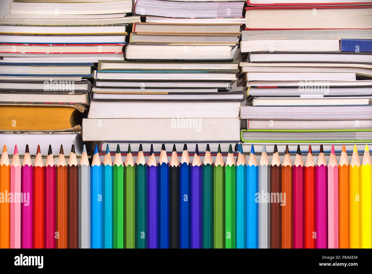 Colorful wooden pencils and piles of books, back to school background concept Stock Photo