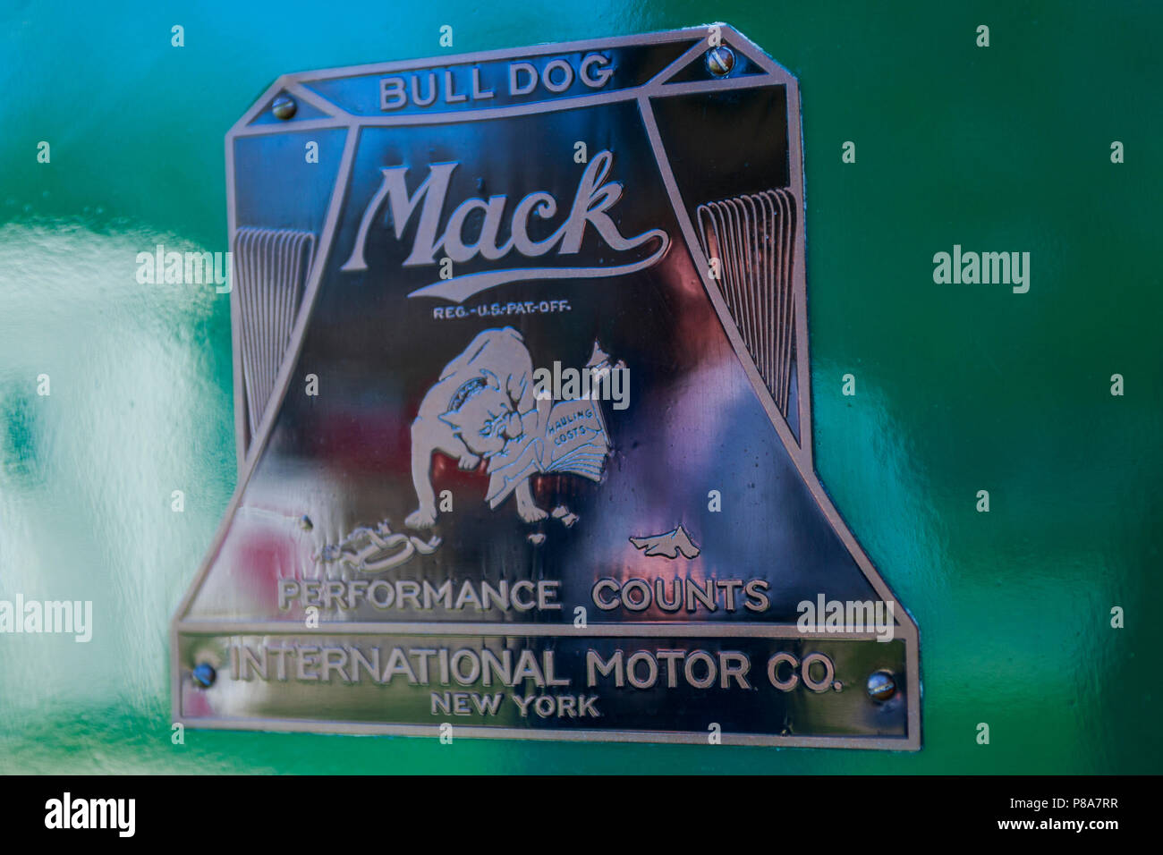 Tight close-up of the first Mack Truck 'Bulldog' logo badge, CA 1921, against green truck body, Carlisle, PA  2018. Stock Photo