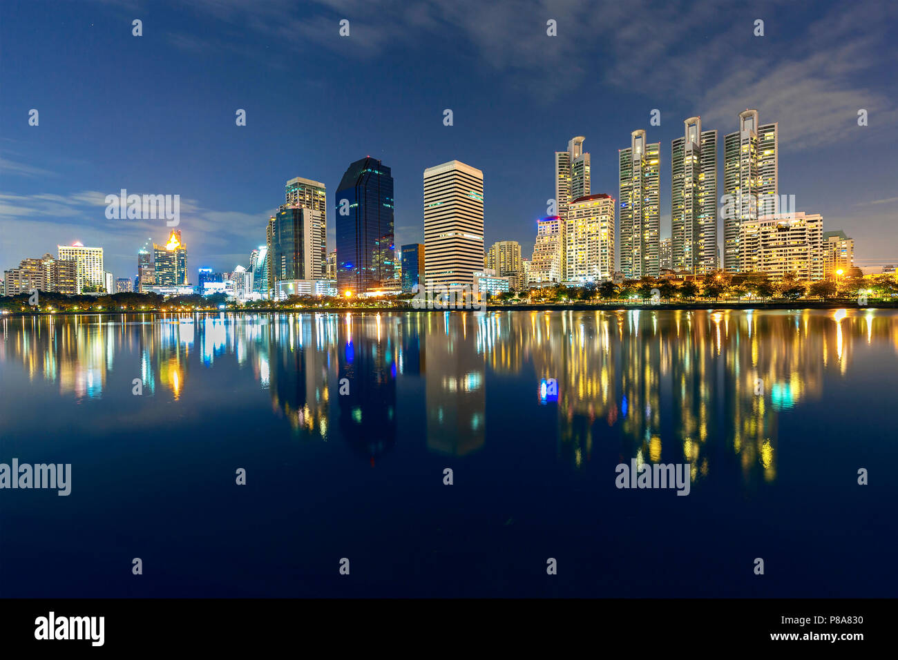 Skyline of Bangkok with reflections in the lake, at the twilight, Thailand Stock Photo