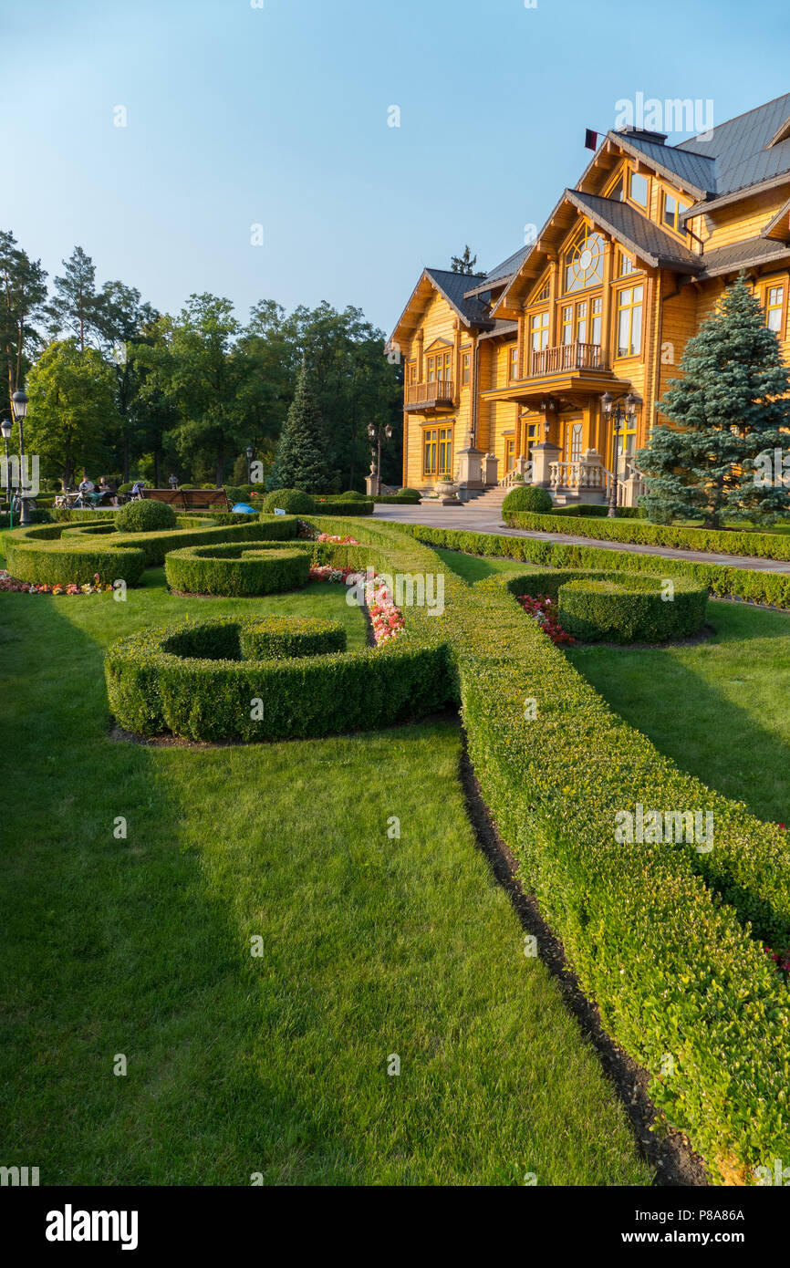 Decoratively trimmed lawn at the entrance to the chic large wooden