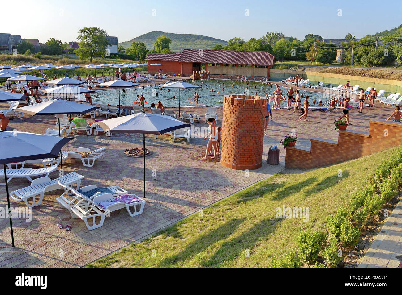 Pool Do Swimming pool with resting tourists with sun beds and umbrellas from ...
