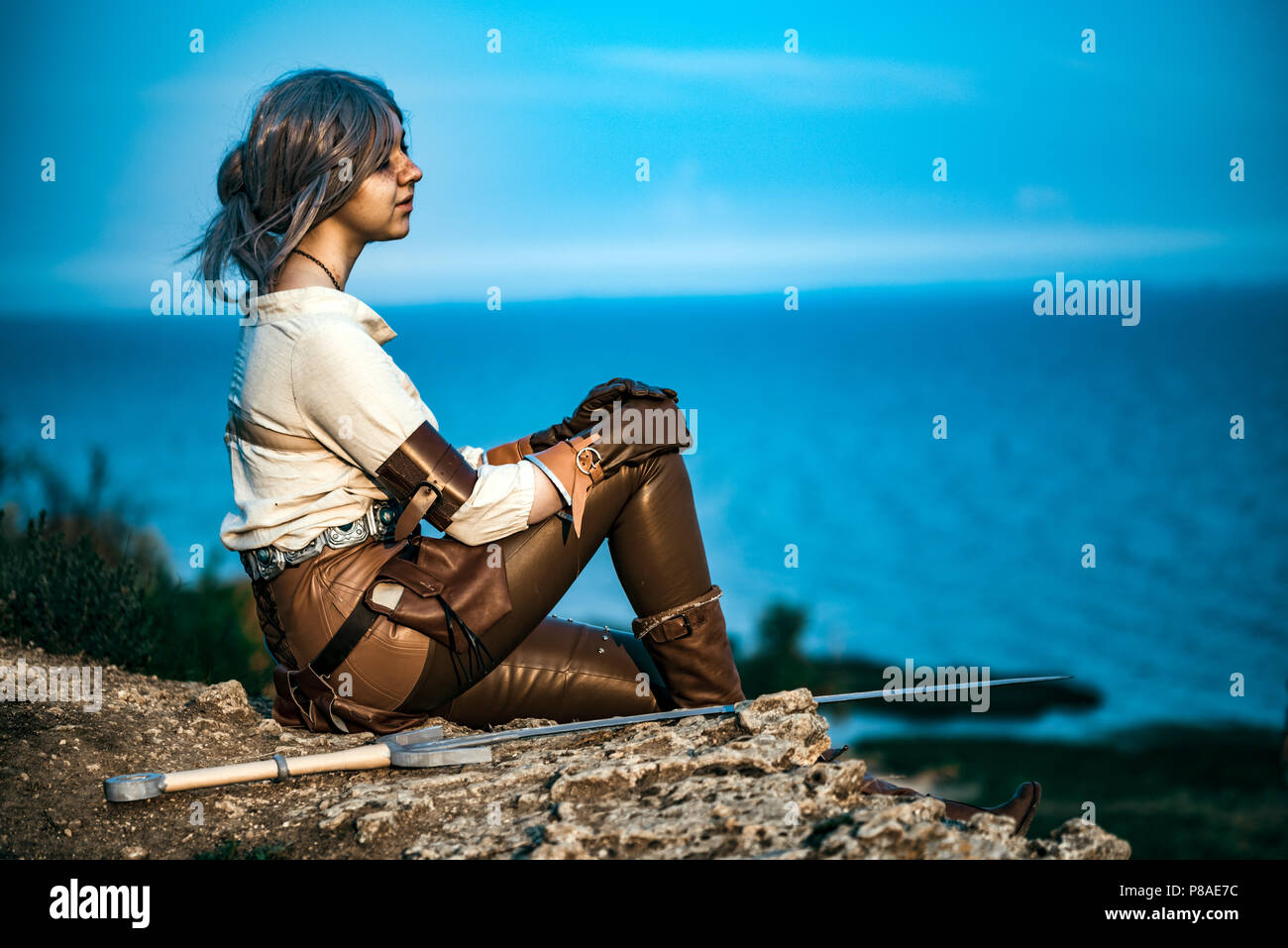 Fantasy cosplay beautiful Witcher girl on cliff Stock Photo