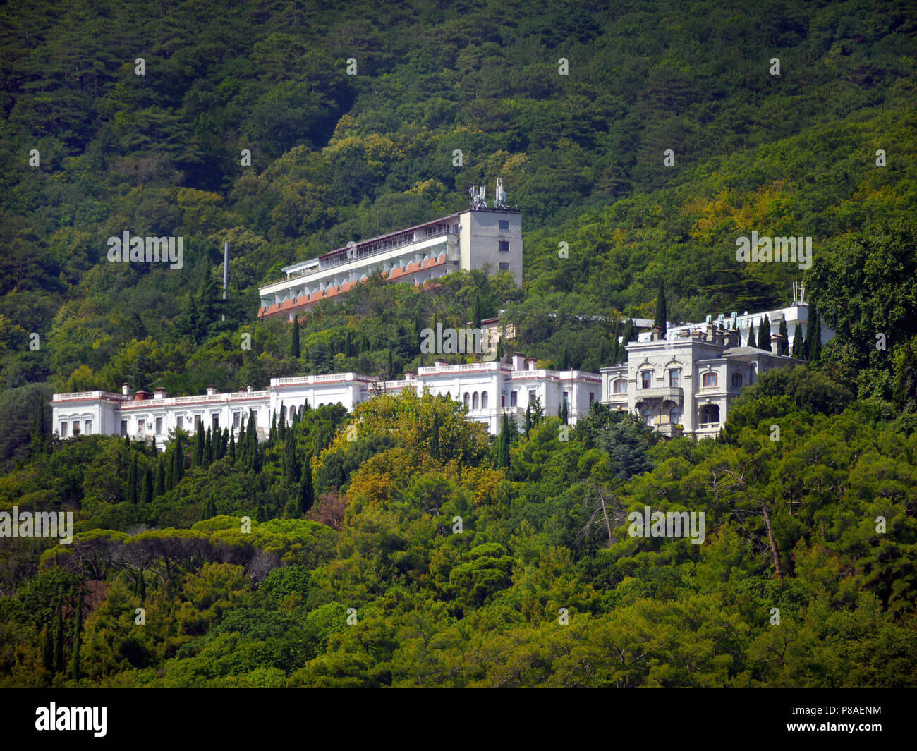Luxurious hotel complexes of white color against the background of high green mountains . For your design Stock Photo