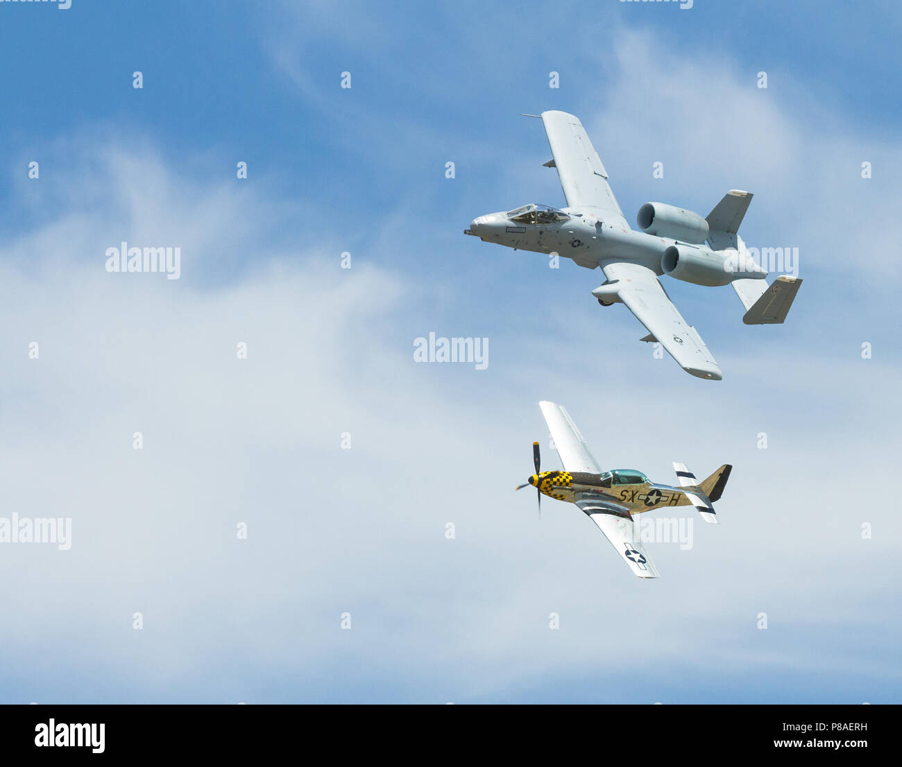 The Modern tank buster a A-10 warthog in a heritage flight with the WWII great the P-51 mustang both banked in flight Stock Photo