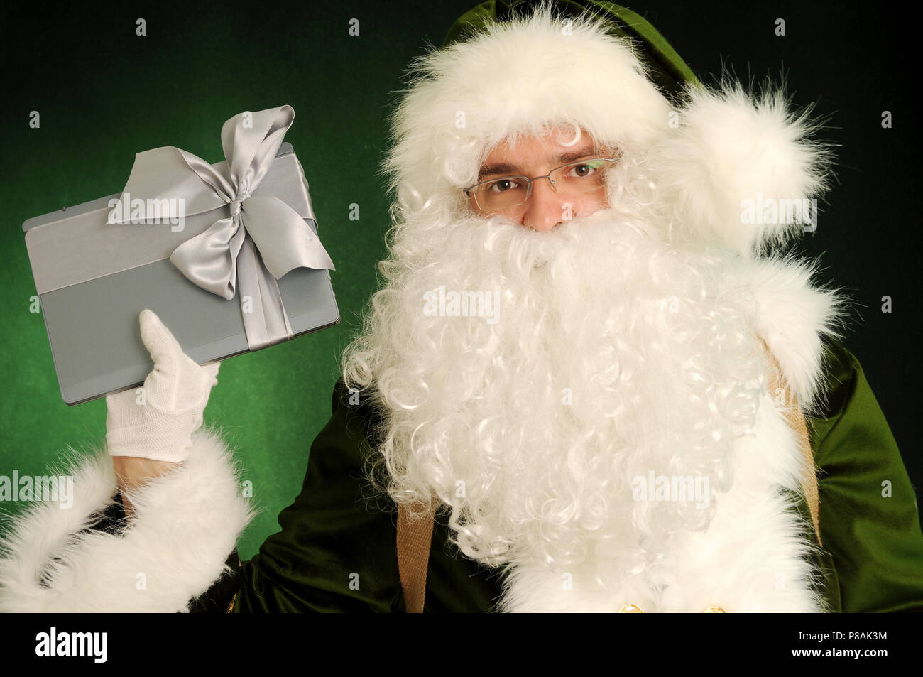 Santa Claus in green suit holding present. Green Santa with laptop ...