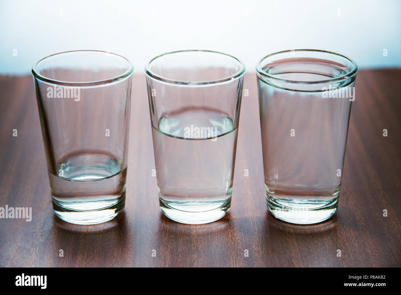studio shot of three water glasses each one have more water than the other Stock Photo Alamy