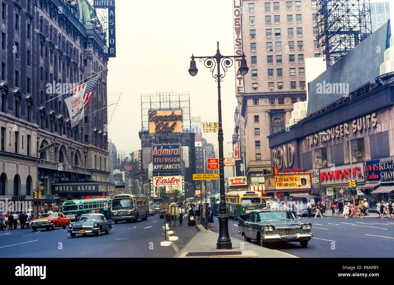 The famed Times Square in New York City, New York, USA, was photographed during the daytime in 1963 prior to its rebirth decades later as the tourist entertainment center that it is today. High-rise office buildings have replaced the 1904 Hotel Astor (left) and 1921 Lowe’s State Theater (right) while the vintage stores have become home to brand-name retailers, restaurants, and family attractions. Flashy digital and neon signs and billboards dominate the lively pedestrian scene that now draws an estimated 50 million visitors a year to this part of Midtown Manhattan. Historical photograph. Stock Photo