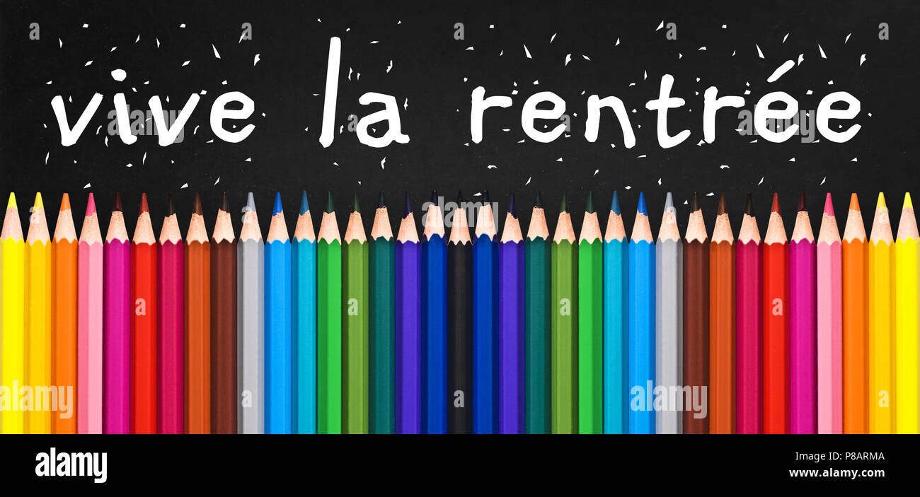 Vive la rentree (meaning Back to school) written on black chalkboard background with colorful wooden pencils Stock Photo